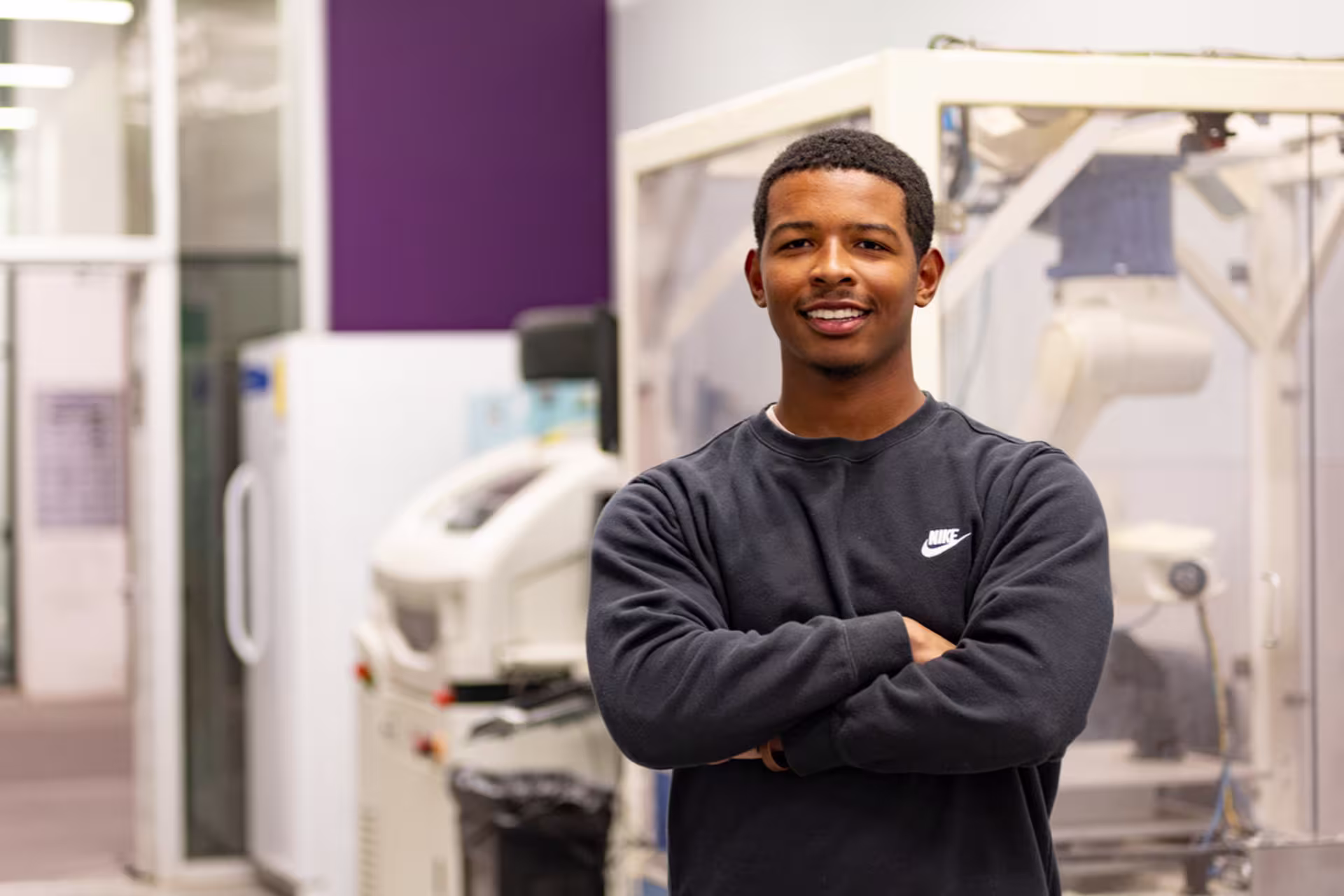 Male engineering student posing for camera in lab setting.