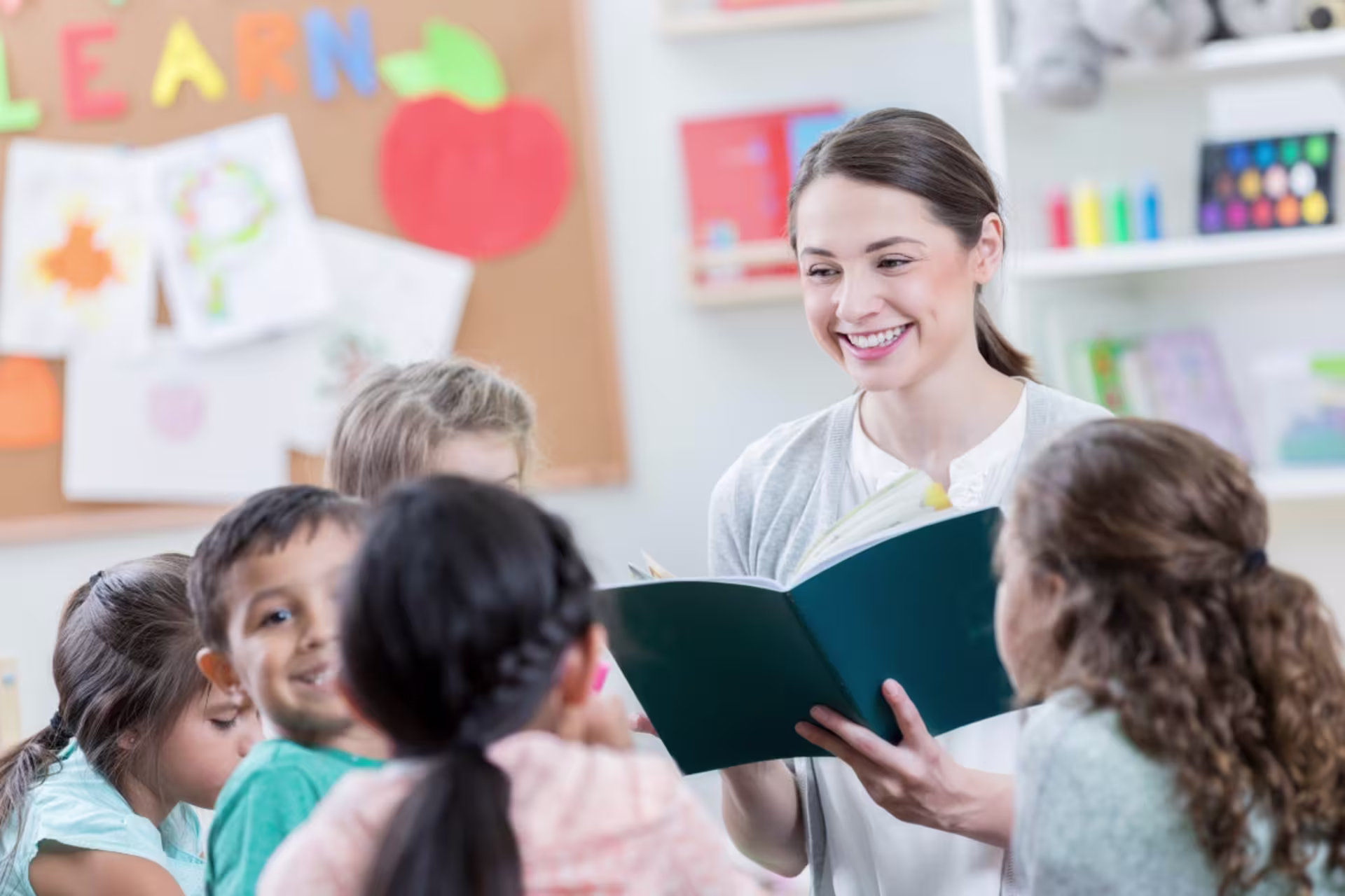 A teacher reads to a group of young children in a classroom setting.