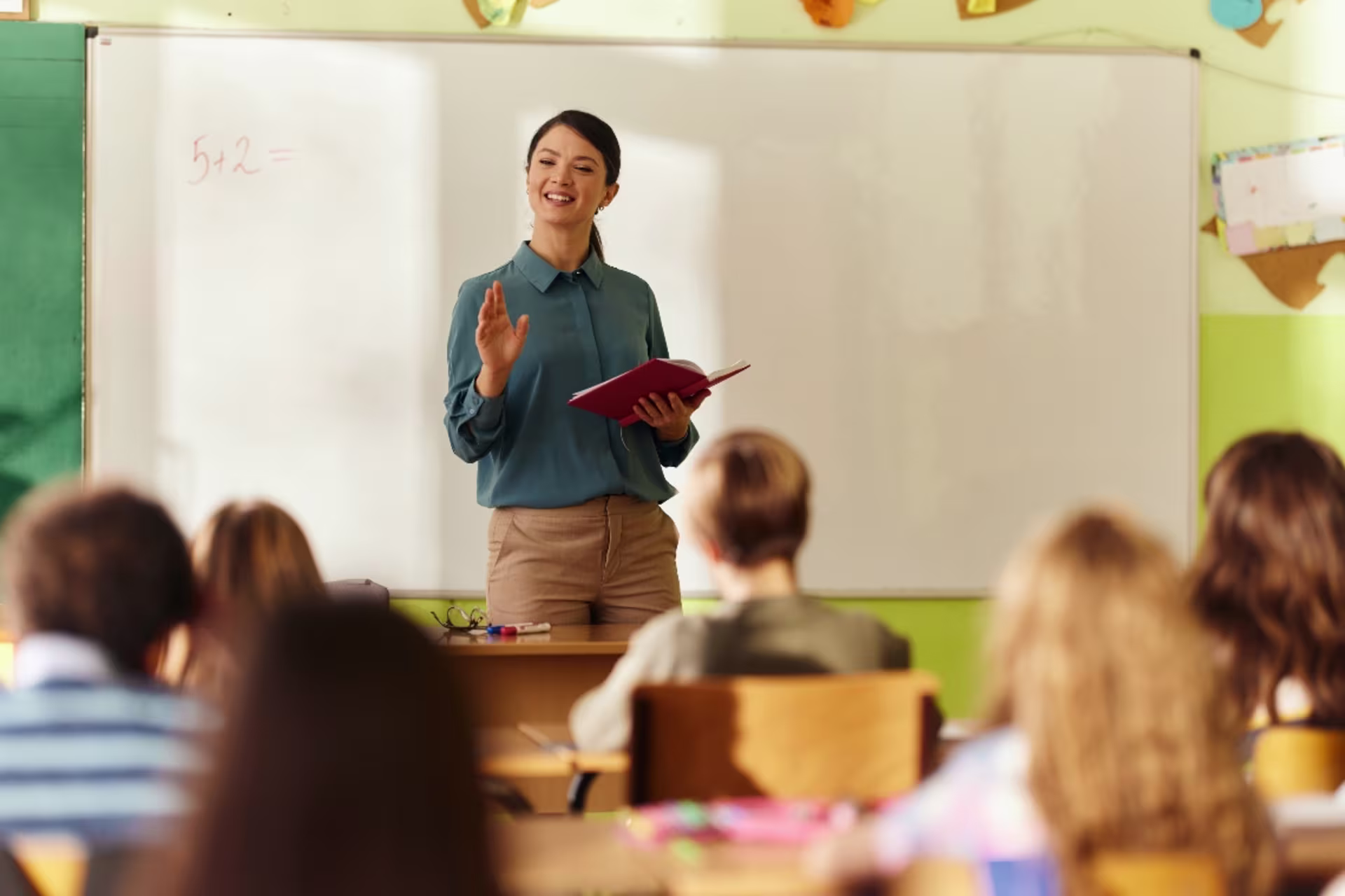 A teacher leads a classroom lesson while speaking to students.