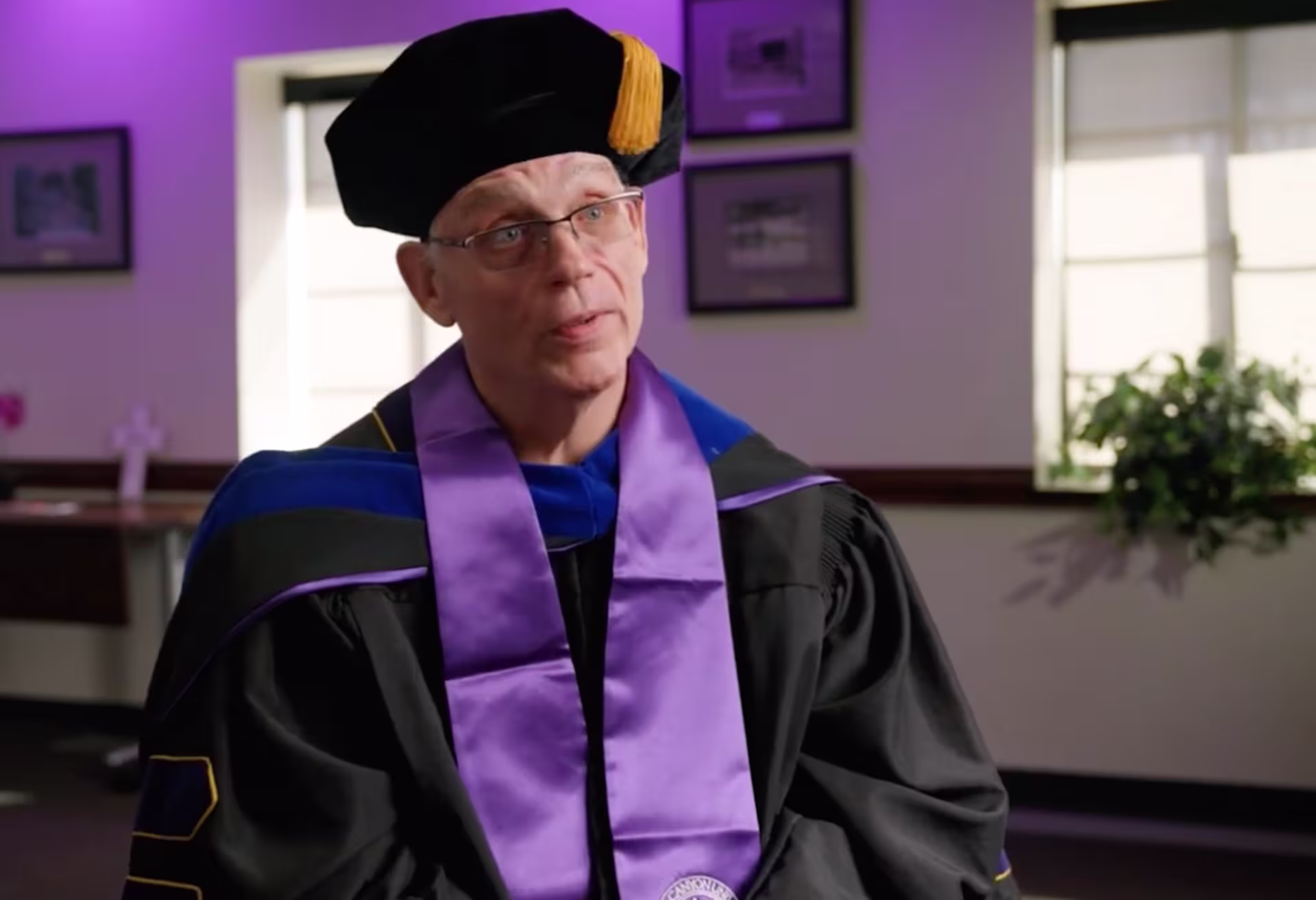 Dr. Ernie Nix, wearing a graduation cap and gown, reflects on earning his PhD in General Psychology from GCU.