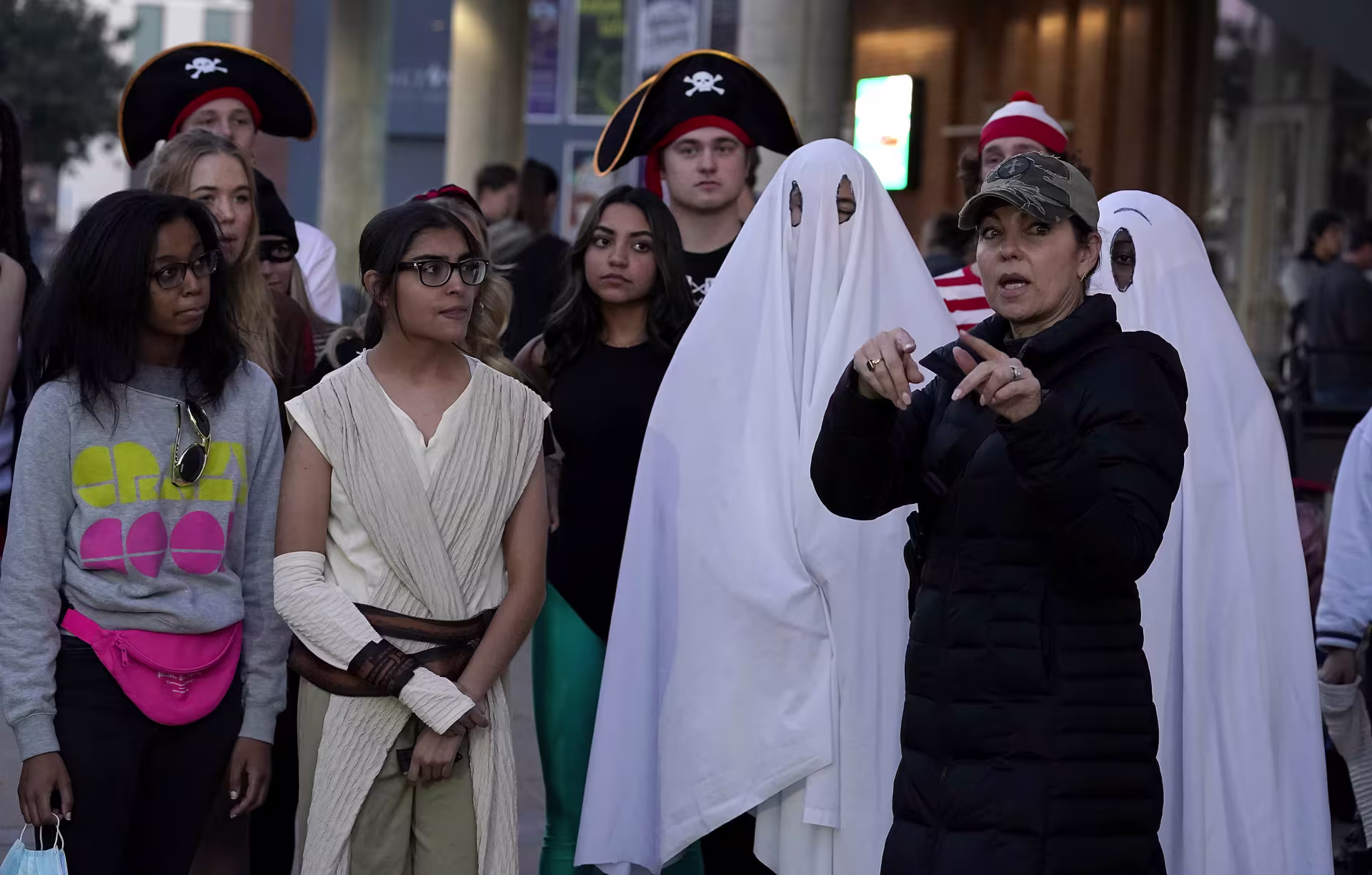 A woman coordinating a group of actors during a film production.