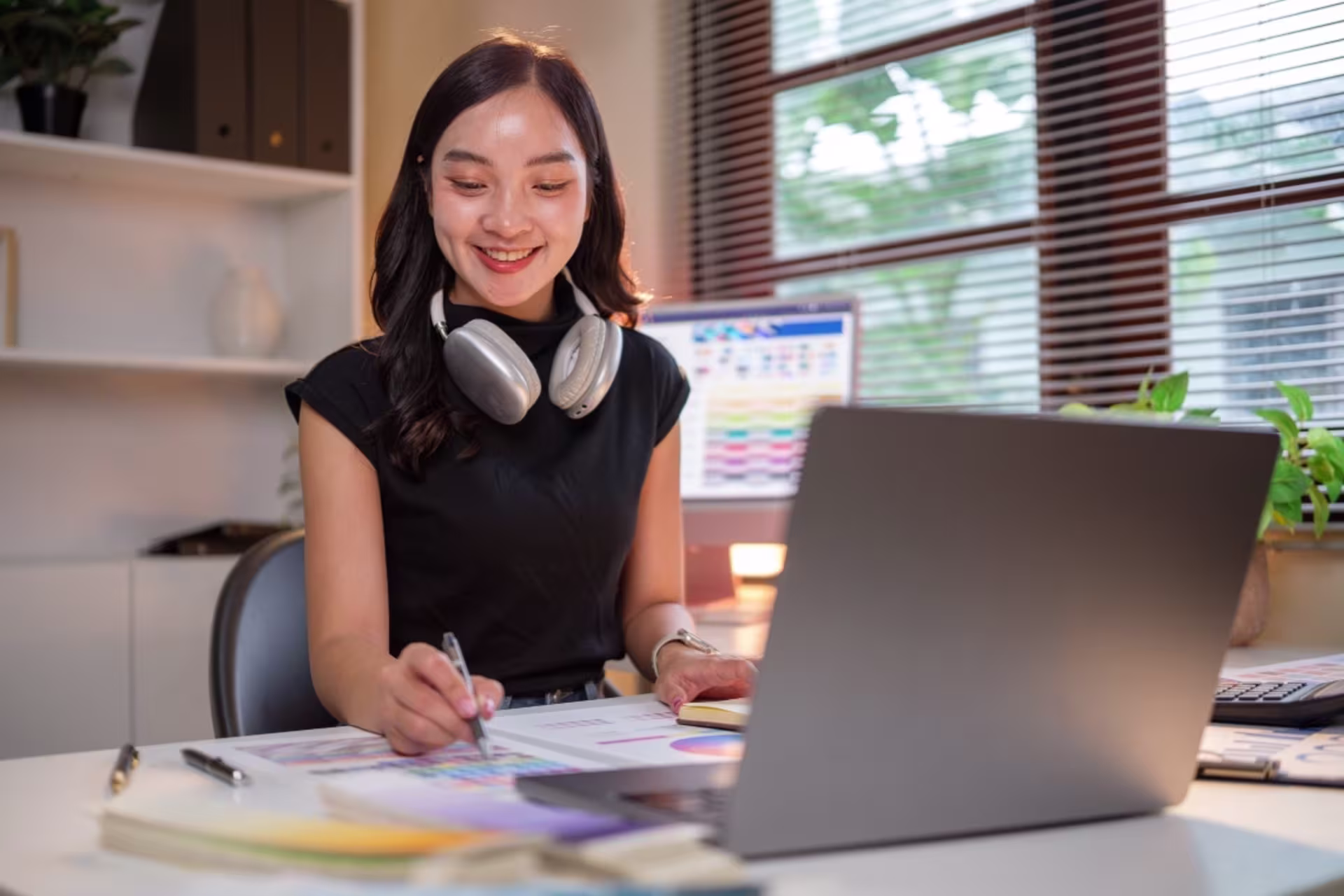 Female BA in advertising and graphic design student working on a design project at a laptop.