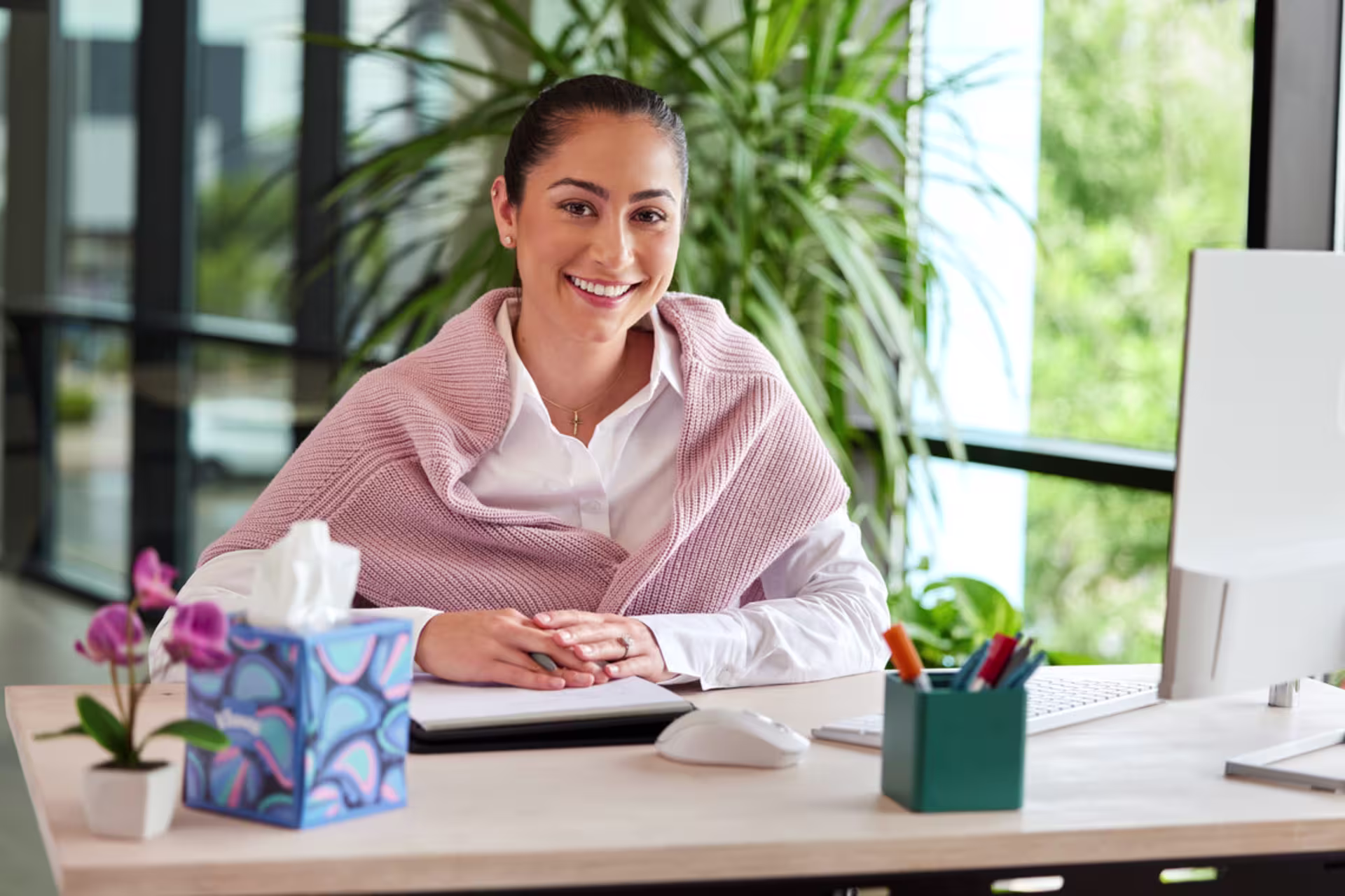 Female counseling student meeting virtually from a professional office setting and smiling at camera. 