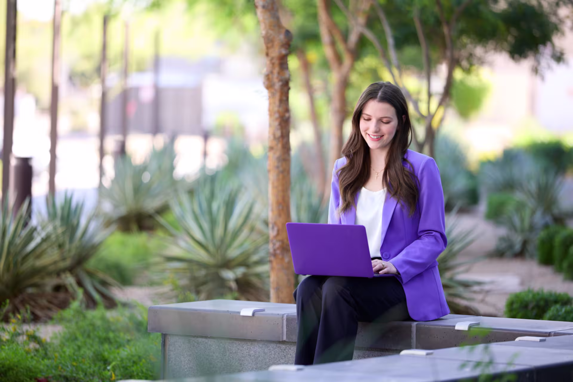 Female premed student studying on a laptop outdoors.