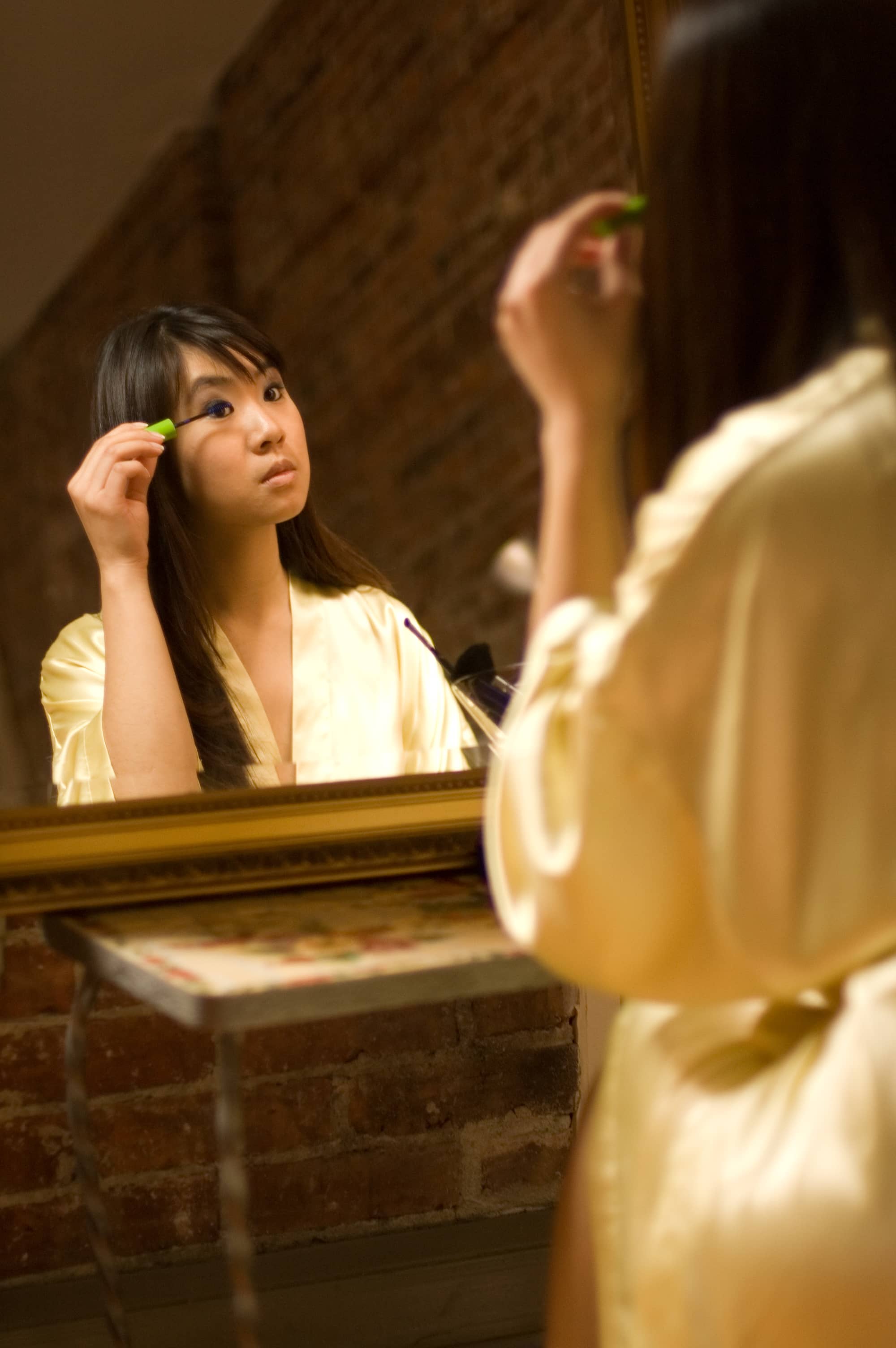 lady looking into mirror doing her make-up