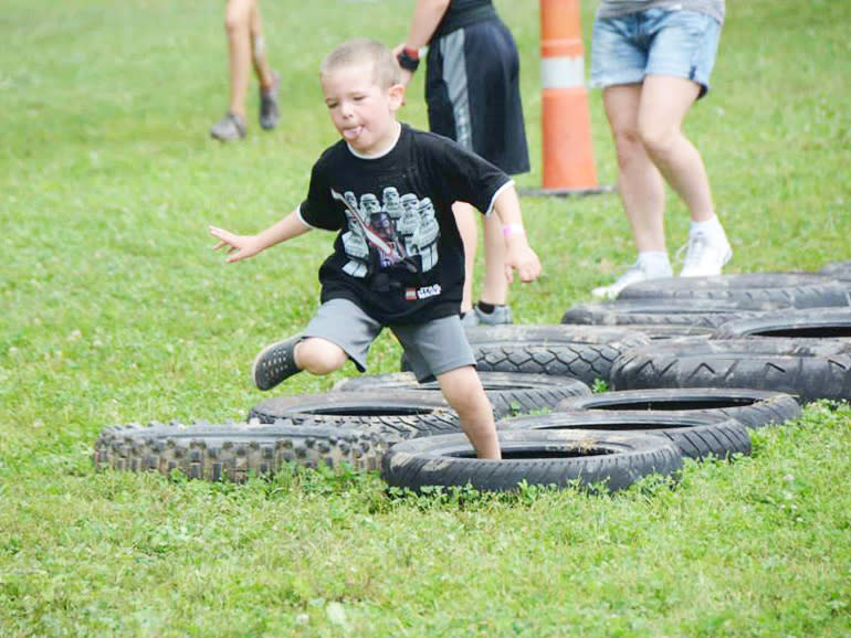 boy hopping through a double-trail of tires