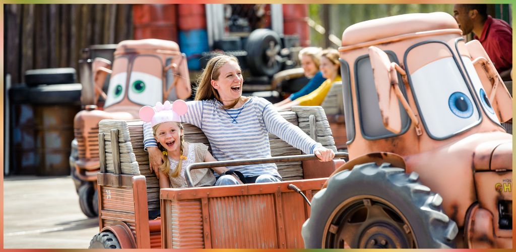 Two children are riding on a fun tractor amusement park ride with animated faces, smiling and enjoying the experience outdoors.
