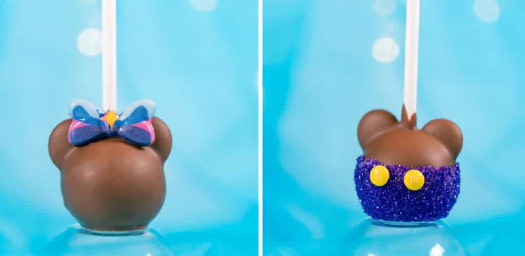 Two chocolate cake pops shaped like mouse ears are displayed. The left pop features a colorful butterfly decoration on top. The right pop is adorned with purple glitter and two yellow buttons resembling short pants. Both are set against a bright blue background.