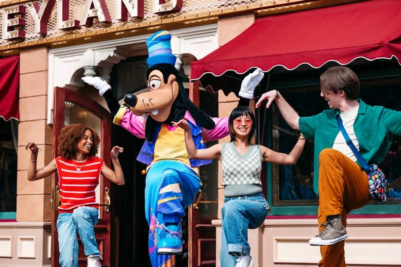 A lively scene from Disneyland California, featuring attractions, visitors, and festive decorations under a clear blue sky.