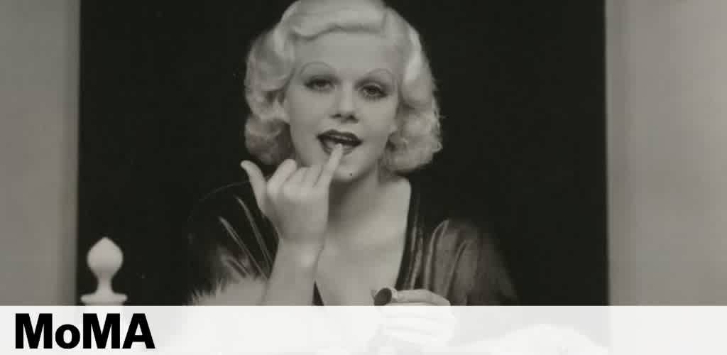 A black and white photo of a person applying lipstick, with
