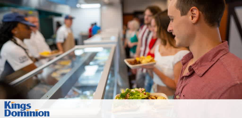 People in line at a cafeteria receiving food from staff behind a counter.