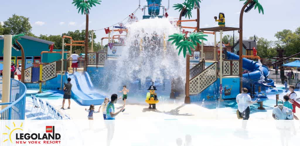 Happy children enjoying interactive water play at LEGOLAND New York Resort, featuring vibrant LEGO-inspired water structures and slides, under a bright blue sky on a sunny day.