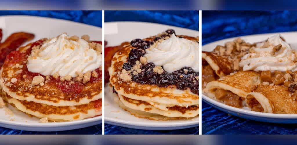 A trio of plates showcasing delicious pancakes topped with different fruit compotes and whipped cream. The left plate features strawberry pancakes with bacon on the side. The middle plate presents blueberry-topped pancakes. The right plate has pancakes with a spiced fruit filling, possibly apple, topped with whipped cream. All served on white plates against a vibrant blue background.