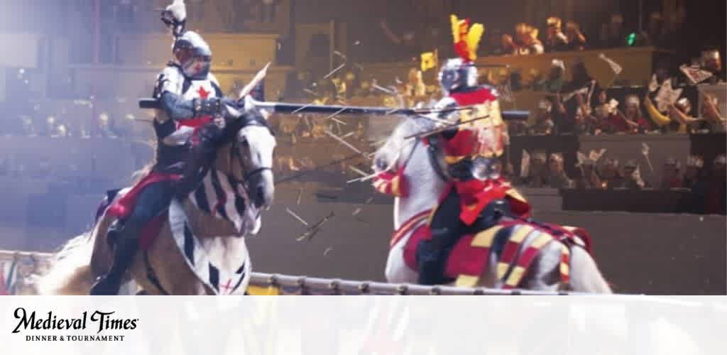 This image showcases a vibrant scene from a Medieval Times Dinner & Tournament. It features two knights on horseback caught mid-joust, with the knight on the left dressed in armor with a blue and white color scheme, while the knight to the right sports red and yellow attire. Both are wearing helmets with face visors, and they are in a stadium with a blurred audience in the background, cheering and waving flags. The energy of the medieval tournament is palpable as the crowd witnesses the exciting clash of the jousters. The arena is dimly lit, emphasizing the focus on the knights, and lending to the historical atmosphere. The logo for Medieval Times is visible in the bottom left corner, adding a touch of branding to the image.

At FunEx.com, we offer the thrill of jousting tournaments and medieval feasts at discount prices that bring the excitement without breaking the bank. Secure your tickets with us for unforgettable experiences at the lowest prices!