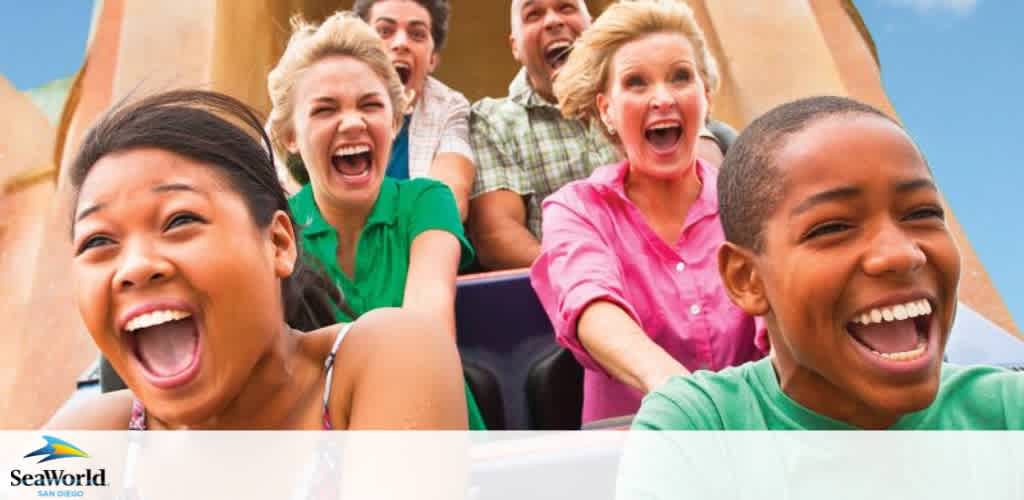 A group of joyful people on a roller coaster ride. In the foreground, a young girl and boy laugh excitedly. Behind them, three adults share in the fun, with expressions of thrill. The sky is clear above them. The SeaWorld logo is visible at the bottom left.