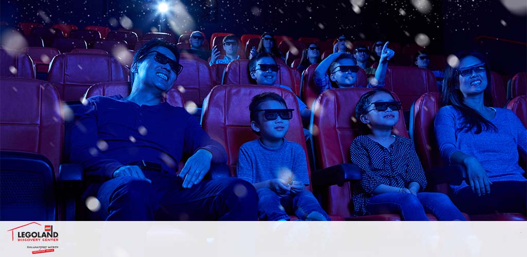 Image features a group of people wearing 3D glasses in a darkened movie theater. They are smiling and looking upwards as if watching and enjoying a film. Bubbles are superimposed on the image suggesting a lively, immersive experience. The LEGOLAND Discovery Center logo is visible in the bottom left corner.