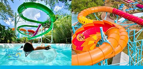 Two colorful water slides at a park, one green and one orange, with people sliding down.