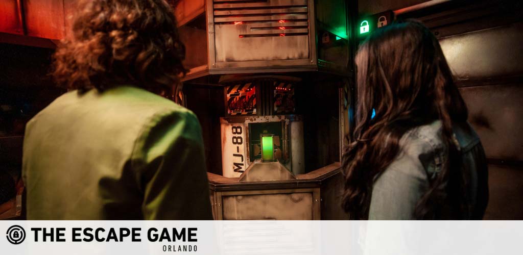 Two people inside a dimly lit escape room, facing a puzzle console.