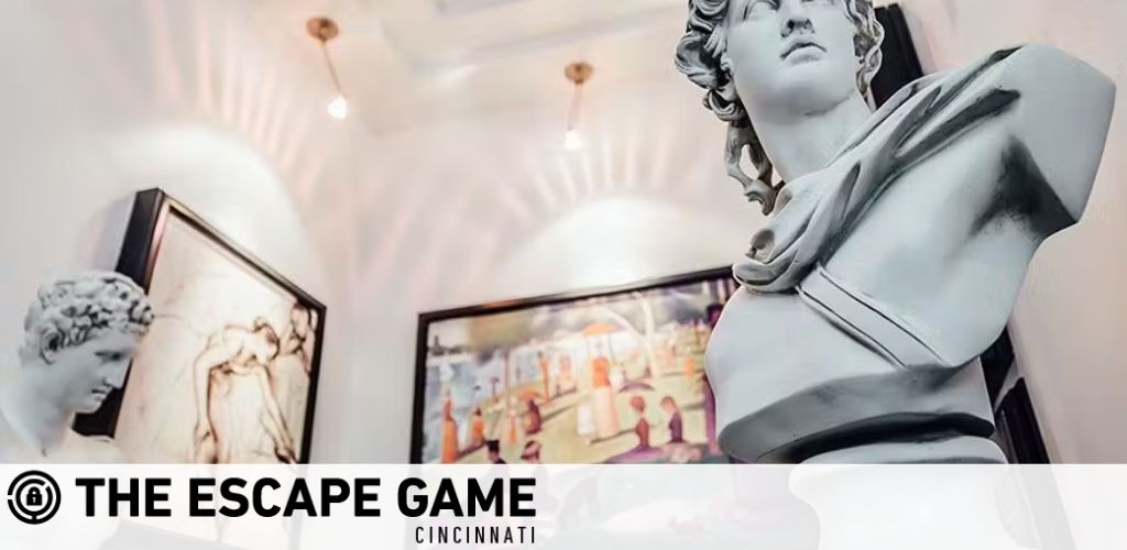 Image displays a promotional banner for The Escape Game Cincinnati, featuring classical white statues in the foreground on either side, evoking intrigue. Background shows framed artworks on a softly-lit wall, suggesting a cultured and engaging atmosphere.