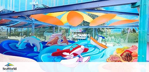 Mural of cartoon sea creatures and a water slide at SeaWorld.