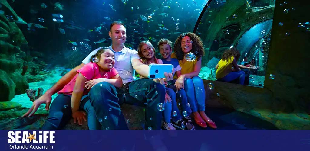Family posing for a selfie at SEA LIFE Orlando Aquarium.