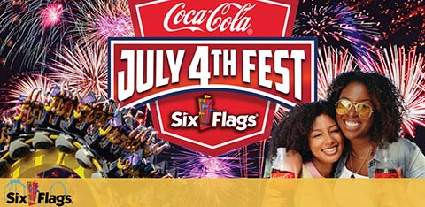 Promotional banner for July 4th Fest at Six Flags sponsored by Coca-Cola. Features a roller coaster with excited riders in the background, and fireworks in the sky. In the foreground, two smiling women hold Coca-Cola cups, with the Six Flags logo displayed at the bottom.