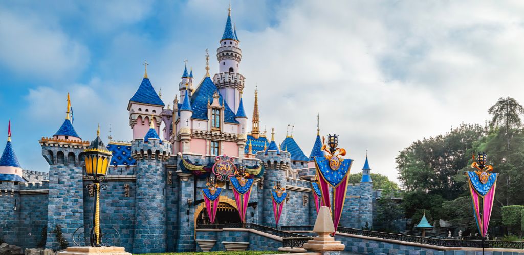 Disneyland castle adorned with blue and gold decorations, showcasing a magical and festive atmosphere.