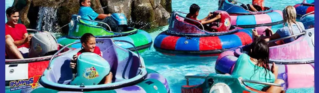 People enjoying a bumper boat ride in a water-filled amusement park.