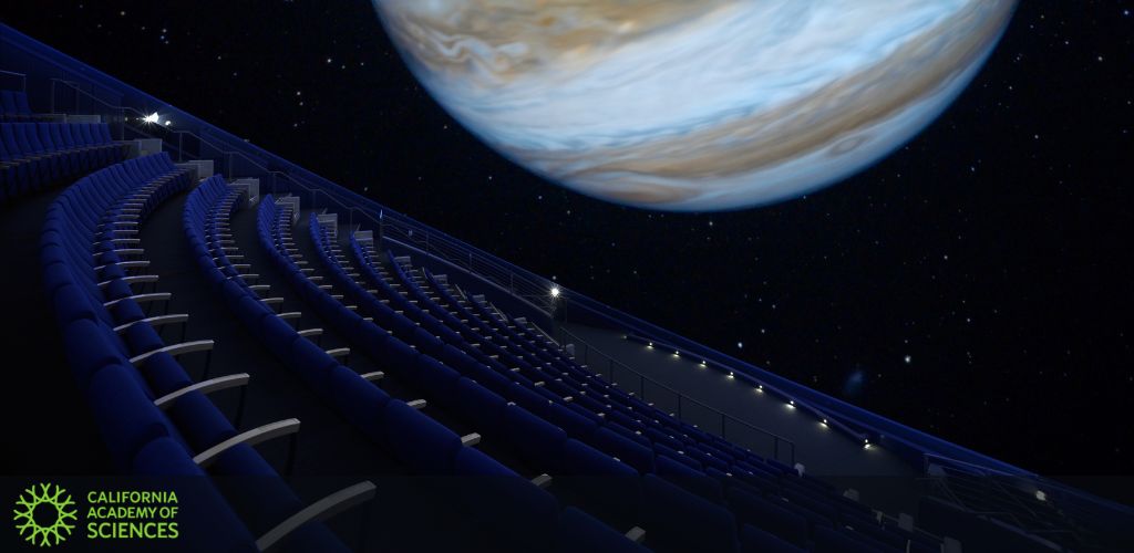 Image shows an empty planetarium with rows of blue seats under a starry sky, featuring a large image of a planet resembling Jupiter. The California Academy of Sciences logo is at the bottom left corner.