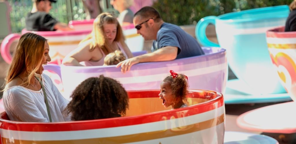 Families enjoying the Mad Tea Party teacup ride at Disneyland Park.