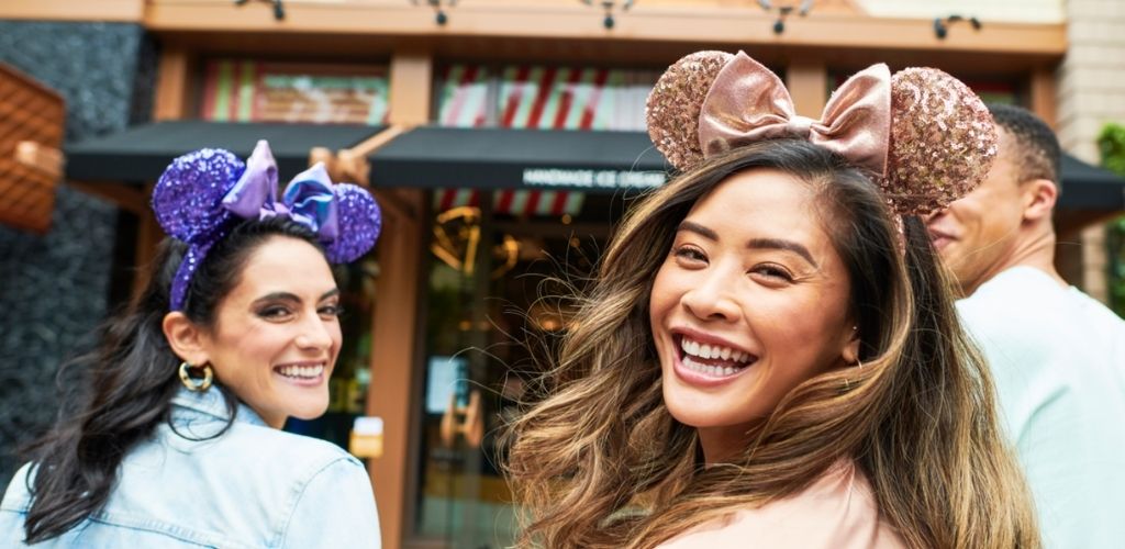 Guests wearing Minnie Mouse ears and enjoying their visit to Downtown Disney District at Disneyland Resort.