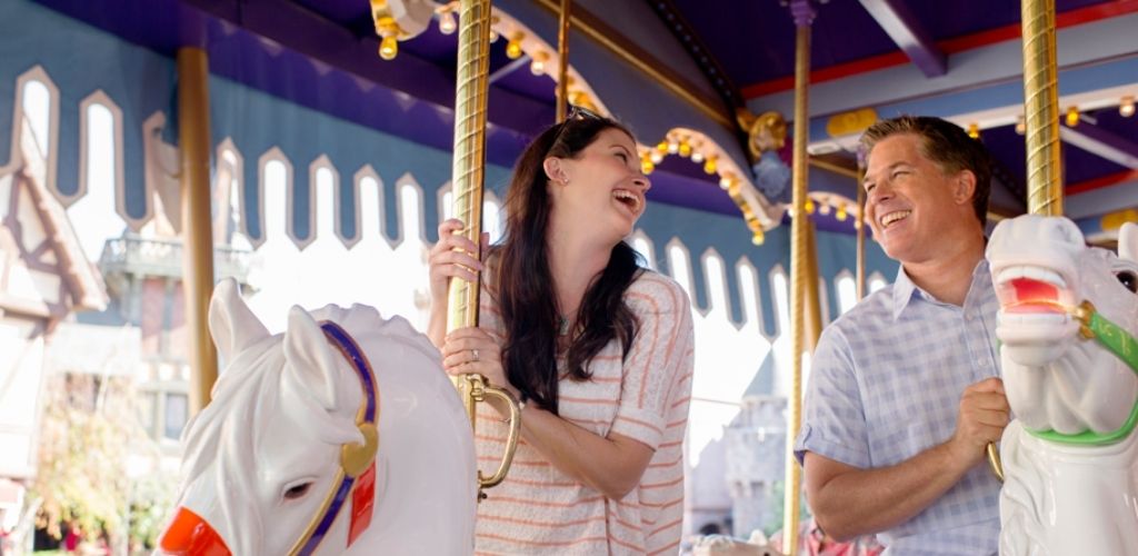 A couple enjoying a ride on King Arthur Carrousel in Disneyland Park.