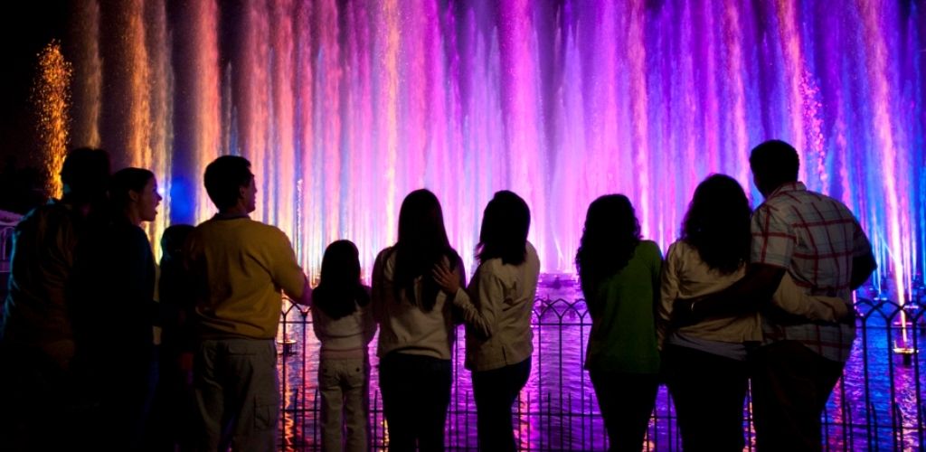 A family watching the vibrant World of Color water show at Disney California Adventure Park.