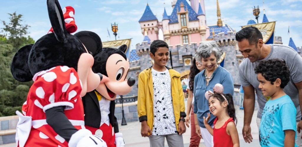 A family meeting Mickey and Minnie Mouse in front of Sleeping Beauty Castle at Disneyland