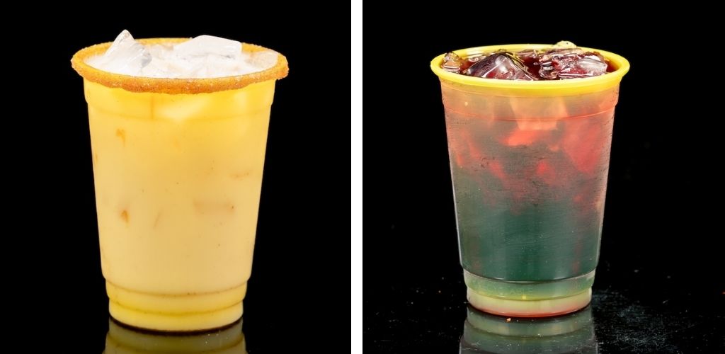 Two plastic cups filled with cold beverages and ice, one with a lemon slice rim and the other with ice cubes on top, on a black background