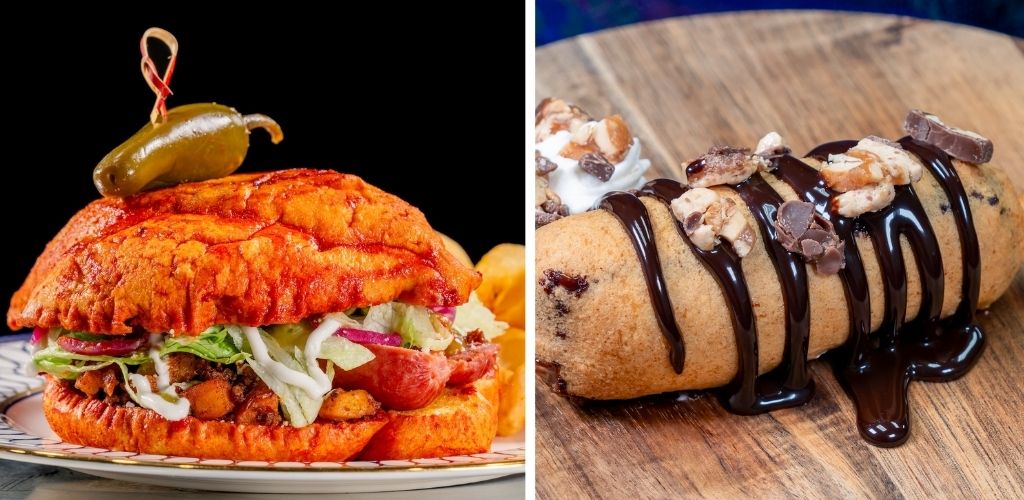 A gourmet fried chicken sandwich with lettuce tomato and pickles on a bun next to a chocolate chip cannoli with chocolate drizzle and nuts on a wooden surface