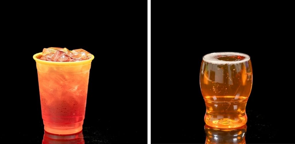 A side-by-side image of a plastic cup filled with ice and a glass of amber-colored beer on a black background