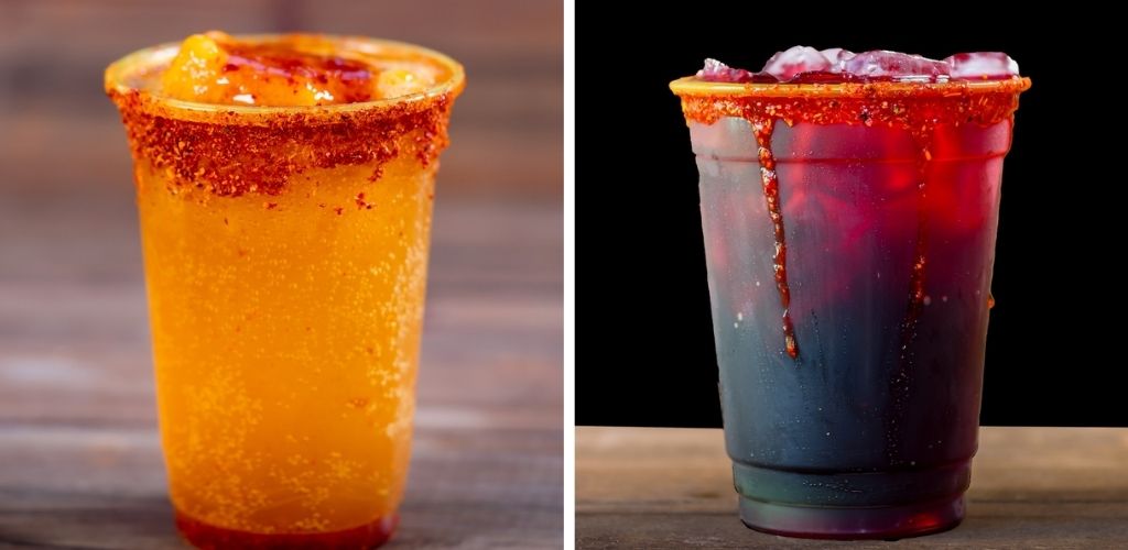 Two drinks in clear cups with salted rims, one with yellow-orange liquid and the other with dark red liquid topped with crushed ice.