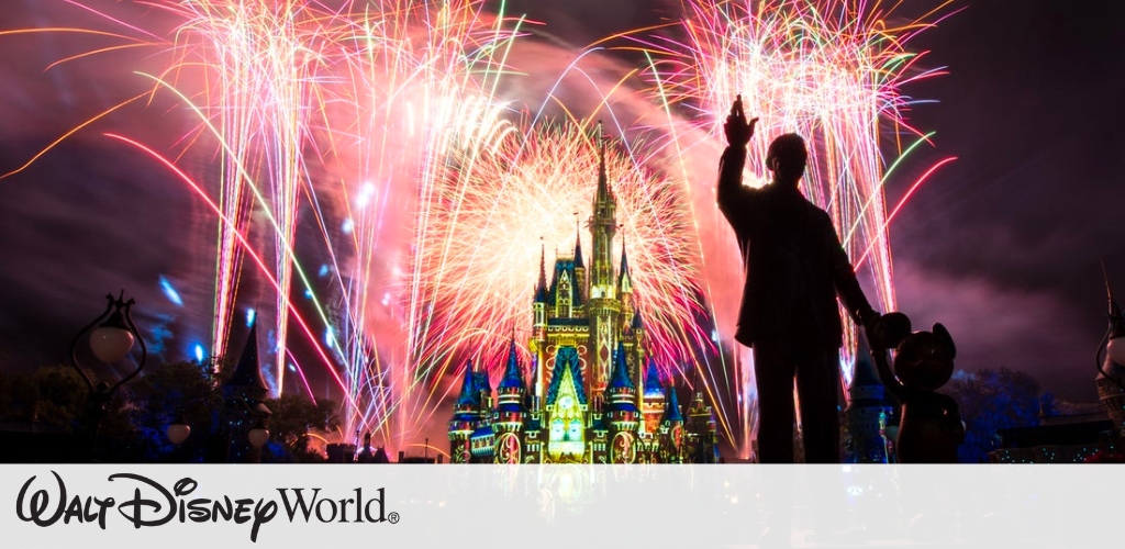A vibrant fireworks display lights up the night sky over a brightly illuminated fairytale castle. In the foreground, the silhouette of a statue stands with an outstretched hand. The scene is colorful and magical, reflecting a whimsical atmosphere perfect for families and fans of fantasy. 