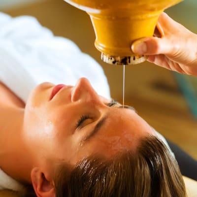 Eine Frau genießt eine Ayurveda-Ölmassage in einem Spa