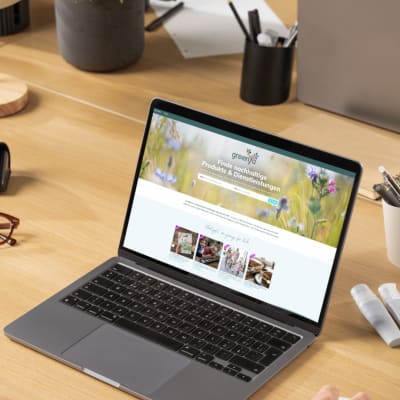 mann der am macbook sitzt und auf der greenya webseite Artikel liest