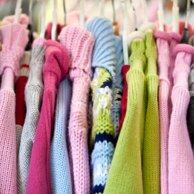 Strickwaren für Kinder auf Kleiderbügeln