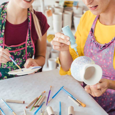 Zwei Frauen bemalen ihr eigenes Keramikgeschirr.