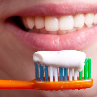 Zahnbürste, Zahnpasta und lächelnde Frau