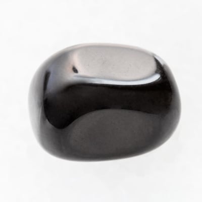 polierter schwarzer Onyx-Edelstein auf weißem Marmoruntergrund