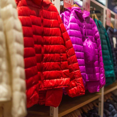 Winterjacken in einem Bekleidungsgeschäft ausgestellt, die eine Vielzahl von Farben für Käufer präsentieren.