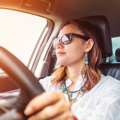 Eine Frau, die gut gelaunt Auto fährt.