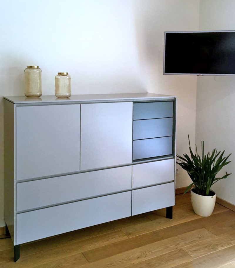 Sideboard nach Maß aus der Tischlerei W&A mit grauen Fronten, Türen und Schubkästen in einem Wohnraum | © W&A Wohnen / Tischlerei