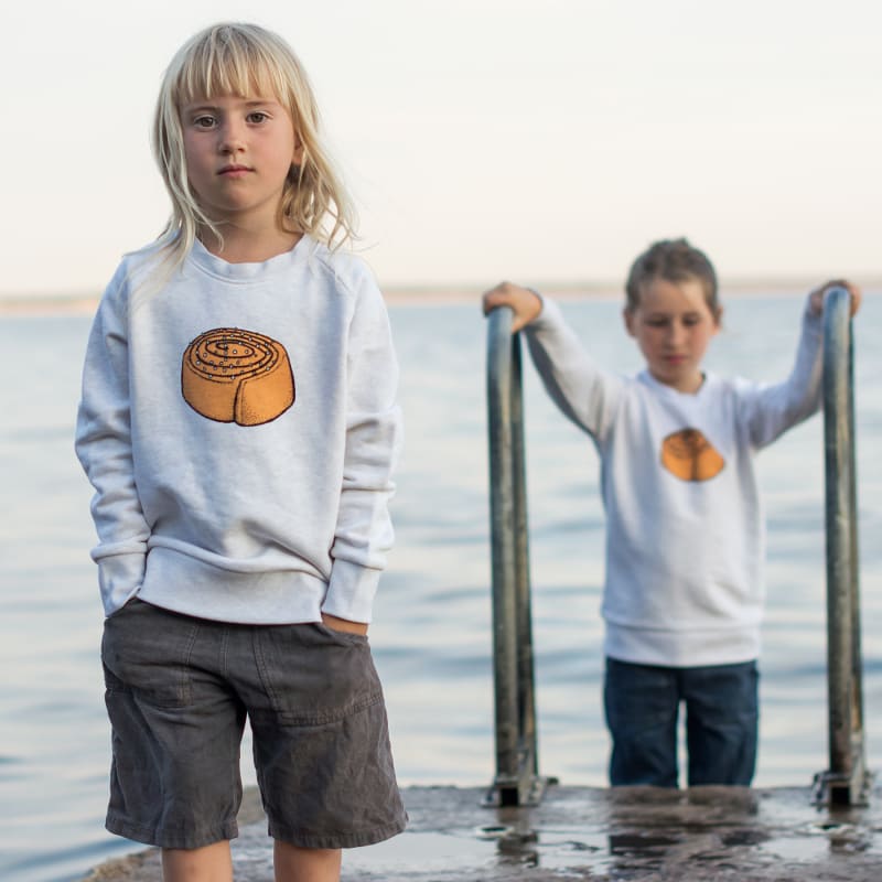 Cmig Kinderpullover mit Zimtschnecken-Motiv – ökologische Mode mit eigener Illustration | © © Cmig, Charlotte und Christoph Sörman GbR