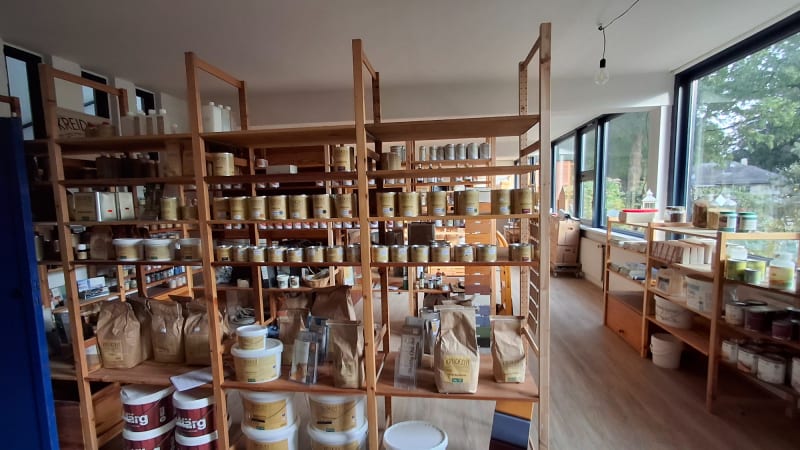 Verkaufsraum mit Holzregalen voller Naturfarben, Putze und Pigmente bei Ökologisch Naturbaustoffe in Hamburg-Bergstedt | © Ökologisch Naturbaustoffe GmbH